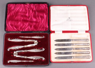 A cased set of 5 silver handled tea knives Sheffield 1920, by Thomas Bradbury & Son, together with 2 pairs of Victorian silver lobster  crackers and picks with embossed shaped silver handles Birmingham 1900 by Adie & Lovekin Ltd,  cased