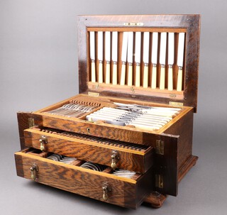 A 106 piece canteen of silver plated Old English pattern flatware comprising gravy spoon, soup ladle, pair of sauce ladles, pair of knife rests, sugar tongs, 11 tea spoons, 12 soup spoons, 4 table spoons, 12 table forks, 12 dessert spoons, 6 egg spoons, 12 dessert forks, 12 table knives, game carver, meat carver, steel, game fork, meat serving fork, all contained in an oak canteen box with hinged lid, fitted 2 drawers  