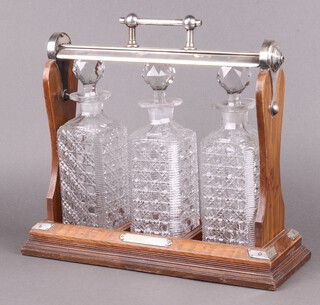 An Edwardian oak and silver plated 3 bottle tantalus with 3 associated hobnail cut glass decanters and stoppers (no key) 