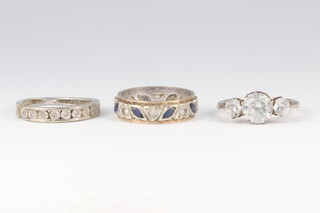 A white and yellow gold marked 9ct eternity ring, set blue and white stones, size K, 3.3g,  a white metal and illusion diamond set ring (a/f) 1.9g gross, together with a paste set ring 
