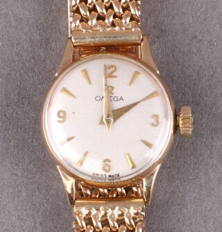 A lady's Omega wristwatch with silvered dial and batons, the movement marked Omega Watch Co Swiss, no. 244 and 14250029, contained in a 9ct gold case with integral bracelet, 27g gross, with original leather box