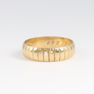 An 18ct wedding band with line decoration, size L 1/2, 3.1g