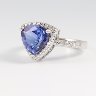 A white gold marked 14K tanzanite and diamond set ring, the centre tanzanite 2.8ct, the diamonds 0.25ct, colour I, clarity SI, with GEM Passport certificate, size L, 5.4g