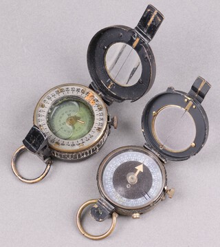 An Koehn prismatic marching compass marked 1917 and with broad arrow together with a T.G. Co. Ltd. compass dated 1940 no.3 and with broad arrow