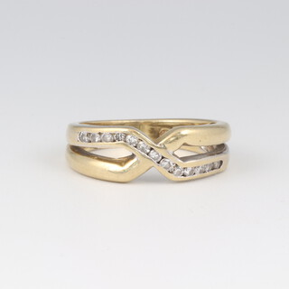A gold marked 750 cross-over diamond set ring, size N, 5g