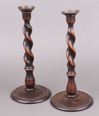 A pair of 1930's oak spiral turned candlesticks with metal sconces 31cm