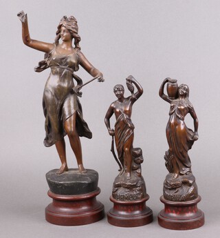 After August Moreau, a spelter figure of a standing lady depicting Industry, raised on a circular base 42cm (fingers a/f), together with a pair of spelter figures Marika and Ahmed 30cm 