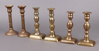 Two pairs of 19th Century brass candlesticks with ejectors, on rectangular bases 18cm and 20cm and a pair of Benares brass candlesticks 20cm 