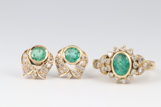 A gold marked 18ct oval emerald and diamond cluster ring size M, together with a matching pair of earrings, 9.4g gross