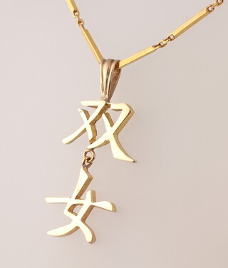 A gold testing as 18ct chain 38cm hung a Chinese script pendant 7.9g 