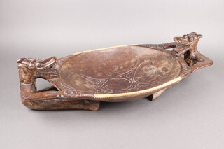 A Dayaka (Borneo) carved hardwood twin handled bowl decorated dragons 13cm h x 70cm w x 36cm 