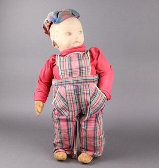 A large Nora Wellings felt doll with sewn label to foot - Made in England by Nora Wellings, with painted face and wearing a fixed tam o'shanter (missing toorie), dressed in tartan dungarees 60cm h