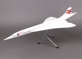 A large scale model of a British Airways Concorde raised on a chrome tripod 61cm l x 26cm w