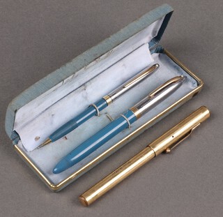 An American Todd & Co Swan fountain pen in a gilt metal case, a Sheaffer fountain pen in blue case the nib marked 14k 585 and matching propelling pencil 