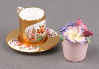 A Coalport porcelain miniature cup and saucer with gilt and floral decoration, the base marked Coalport, A5456 3cm together with a miniature pottery arrangement of flowers contained in a small vase 4cm 