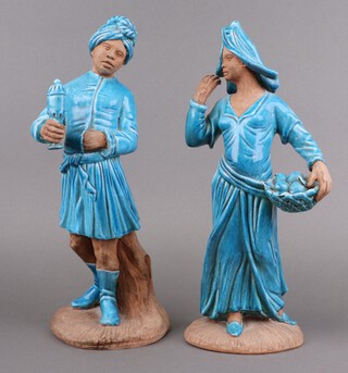 A pair of Italian blue glazed pottery figures of standing servants 40cm, 1 with tray of fruit, 1 with a lidded casket 