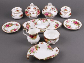 A collection of Royal Albert Old Country Rose pattern table china including pair of lidded sugar bowls (1 with chips to rim and a 2nd), pair of squat circular lidded urns, twin handled oval tray (second), sugar bowl and cream jug (seconds), 2 circular dishes (seconds), shaped dish (second) and a ring stand 