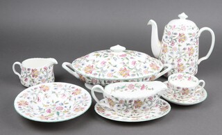 A 99 piece Minton Haddon Hall dinner service comprising 2 tureens and covers, oval meat plate, 12 dinner plates, 11 side plates, 12 tea plates, sauce boat and stand, 12 pudding bowls, 12 twin handled soup bowls and saucers, coffee pot, cream jug, 10 cups, 10 saucers, sugar bowl and small dish 