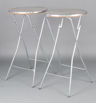 A pair of circular folding metal bar tables, raised on tubular supports, 112cm h x 59cm  (some rust in places) 