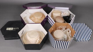 A purple hat box containing 2 ladies hats and 3 fascinators and 3 other hat boxes containing 4 hats 