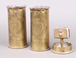Two 1914 brass trench art vases formed from brass shell cases marked "The Great War 1914-1918, Ypres Sommes Aisne Marne" together with an ashtray incorporating a match box (glued) 