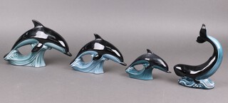 Three graduated Poole Pottery figures of dolphins and 1 of a whale 