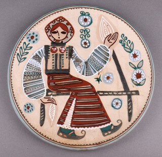 A Russian pottery plate decorated a woman in traditional costume 