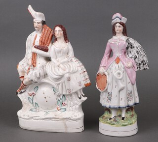 A Victorian Staffordshire figure of a standing lady with tambourine 35cm and 1 other of a seated Scotsman and lady by a clock 36cm (crack to back) 