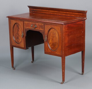 An Edwardian inlaid mahogany washstand/dressing table with raised back, the base fitted a drawer flanked by cupboards, raised on square tapered supports 91h x 107w x 50d