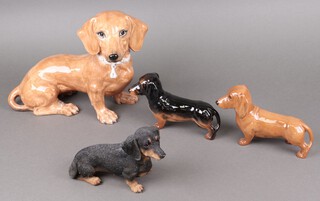 Two Beswick figures of Dachshund 24cm and 22cm, a pottery Dachshund and a resin ditto 