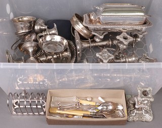 A pair of silver plated twin light candelabrum, pair of plated bottle coasters, a pair of cut glass knife rests, a pair of silver plated knife rests, a small collection of flatware, 2 entree dishes and other items of silver plate, contained in a plastic box