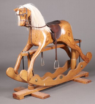 An Ian Armstrong carved wooden rocking horse with cruciform base 114cm h x 130cm l x 51cm w 