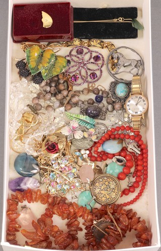 A collection of costume jewellery including an amber coloured bead necklace and a quantity of brooches 