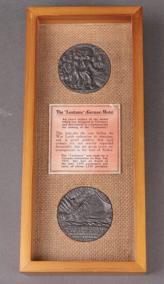 Two facsimile Lusitania medals in a pine frame 