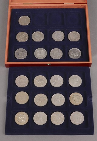 A collection of Elizabeth II cupronickel commemorative crowns 1951-2000 (except 1996) including Nelson and Trafalgar crowns (2005)  and 4 Guernsey crowns, contained in a rectangular mahogany box with hinged lid 