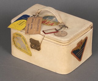 A 1950's white leather finished vanity case with various airline stickers including B.O.A.C, BEA etc