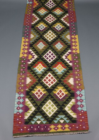 A black, green and purple ground Maimana Kilim runner 290cm x 87cm 
