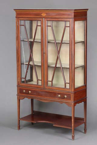 An Edwardian inlaid mahogany display cabinet with moulded cornice, fitted a shelf enclosed by astragal glazed panelled doors, the base fitted a drawer above recess, raised on square tapered supports with spade feet 166cm x 93cm w x 57cm d 