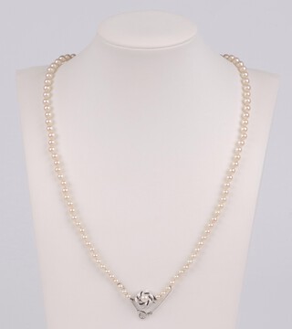 A string of cultured pearls with white metal marked 585 pearl set clasp and safety chain 50cm