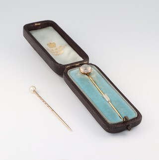 Two yellow metal tie pins, one set a pearl the other a moonstone with original box 