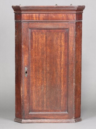 An 18th Century mahogany hanging corner cabinet with moulded cornice, fitted shelves enclosed by a panelled door 112cm high x 69cm wide x 48cm d 