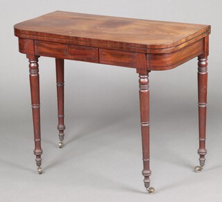 A 19th Century mahogany D shaped card table fitted a drawer with green baize top, raised on ring turned supports, brass caps and casters 76cm h x 91cm w x 45cm d 