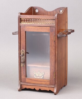 An Edwardian oak smoker's cabinet, the upper section with gallery and pierced front, fitted a pipe rack above drawer enclosed by glazed panelled door 32cm h x 16cm w x 16cm d 