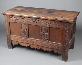An 18th Century carved elm coffer of panelled construction, the interior fitted a candle box 76cm high x 132cm w x 57cm d 