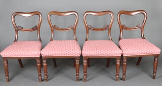 A set of 4 Victorian mahogany spoon back dining chairs with carved mid rails and over stuffed seats, raised on turned supports 