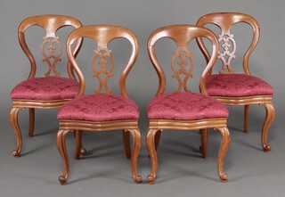 A set of 4 Victorian bleached mahogany splat back dining chairs with drop in seats of serpentine outline, raised on cabriole supports 