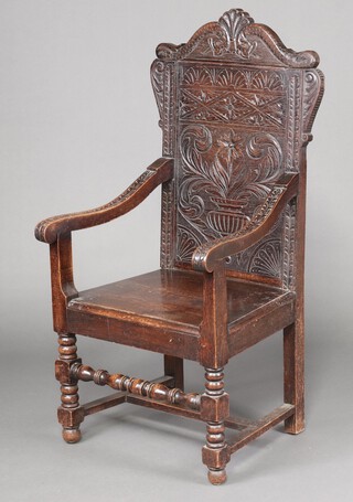A Victorian 17th Century style carved oak Wainscot chair with solid seat and back, raised on turned and block supports 