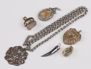 An oval brilliant set locket marked 900, a gilt metal charm, gilt metal locket, silver chain, tooth pendant and a seal 