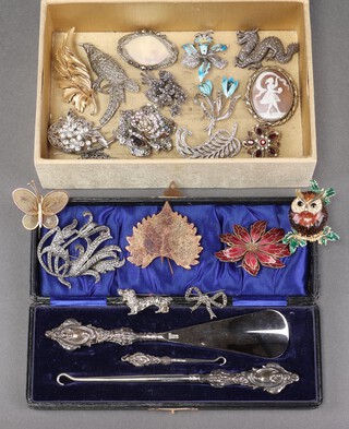 A shoe horn with silver mount and 2 button hooks with silver mounts, cased, a shell carved cameo brooch in a gilt metal mount, a marcasite brooch in the form of a dragon and other brooches, contained in a rectangular box with hinged lid 