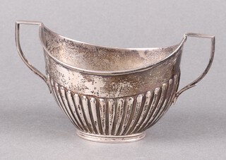 An Edwardian oval silver twin handled bachelor's sugar bowl with demi-reeded decoration, London 1908 by William Hutton & Sons Ltd. 94g 